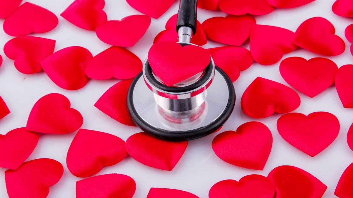 a stethoscope surrounded by hearts on a white surface