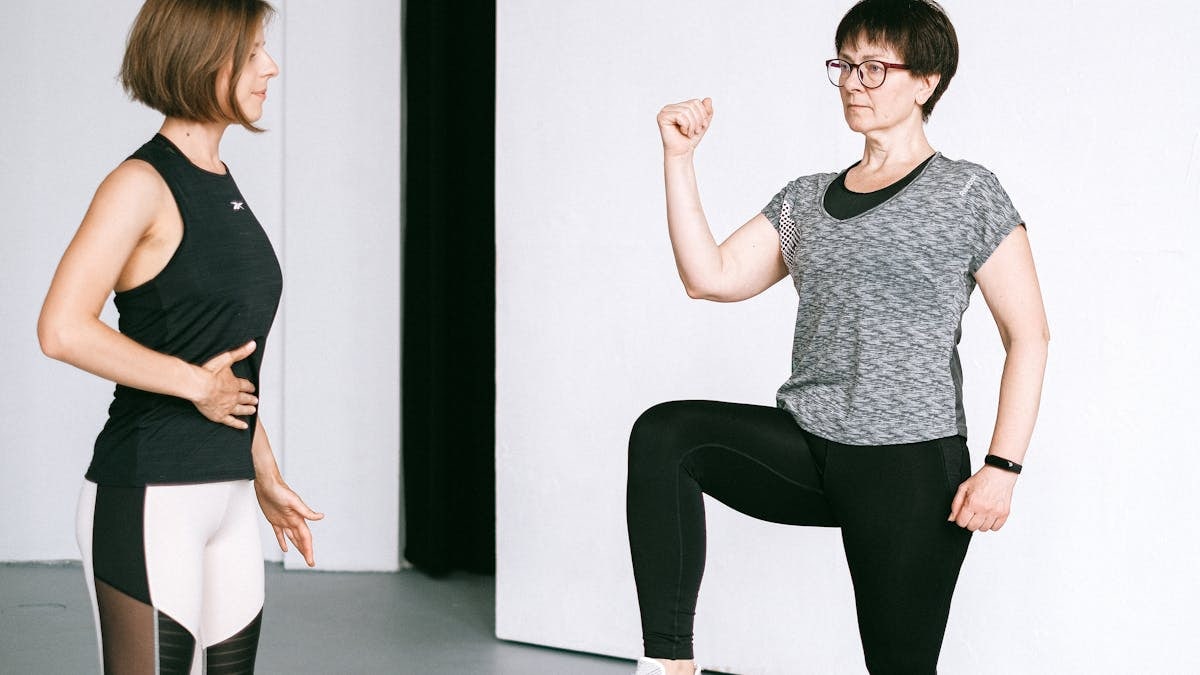 Two women working out together, demonstrating fitness exercises on a white background.